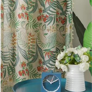 Detail of Nordic linen curtain with tropical plant prints and cream tassel ball trim