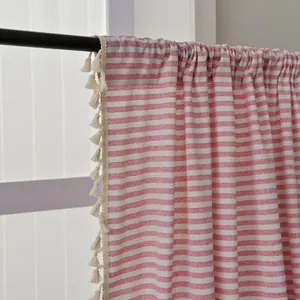 Detail of red and white striped cotton linen curtain with decorative beige tassels on rod