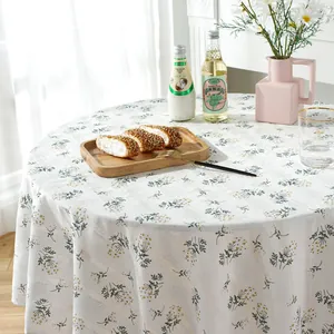 Close-up of floral embroidery on white cotton linen round tablecloth with draping detail