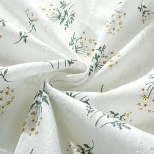 Detail of floral linen tablecloth showing soft texture and yellow daisy patterns