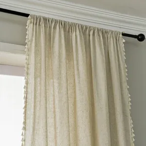 Detailed view of beige cotton linen curtain with tassel trim and rod pocket header