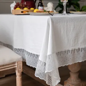 Detail van wit katoenen linnen tafelkleed met fijne meteor-kant voor een elegante tafel
