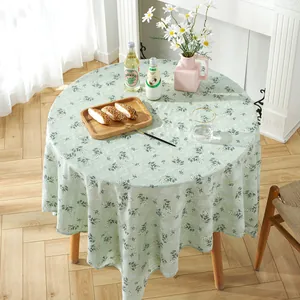Detailed top view of light green floral round tablecloth with rustic embroidery draping