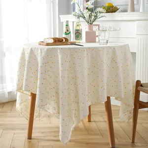 Close-up of cream cotton tablecloth featuring yellow polka dots and natural texture