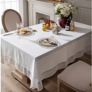 Detail van wit rechthoekig tafelkleed met Franse kanten rand voor elegante tafeldecoratie