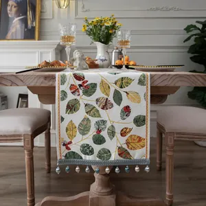 Dettaglio del runner da tavolo jacquard geometrico con motivi a foglia e nappe di perline