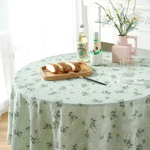 Detail of light green floral round tablecloth with elegant drape in a cozy home setting