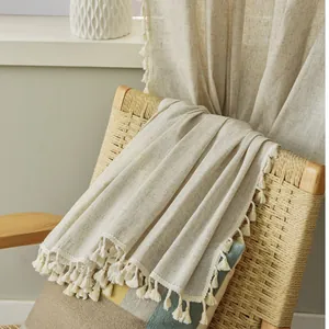 Detailed view of Nordic beige cotton linen fabric with elegant fringe tassels and texture