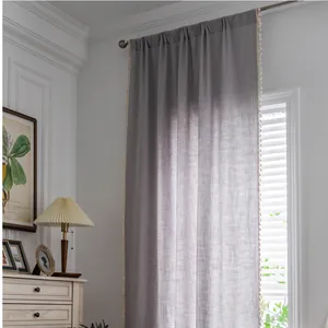 Grey linen textured semi-blackout curtain with cream tassels and rod pocket header