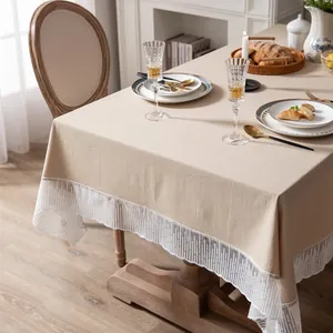 Detail van elegant Frans tafelkleed met witte kanten randen en verfijnde beige stoffering