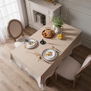 Detailopname van beige tafelkleed met elegante witte geplooide franje kanten rand
