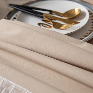Macro-opname van beige tafelkleed met textuur en fijne witte kanten randafwerking