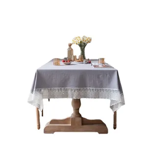 Elegant rectangular gray tablecloth with white lace floral borders on a wooden dining table