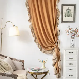 Detail von karamellfarbenen Vorhängen mit beigen Rüschen in einem Retro-Wohnzimmer