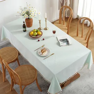 Gros plan d'une nappe en coton et lin vert menthe avec des détails de franges à glands