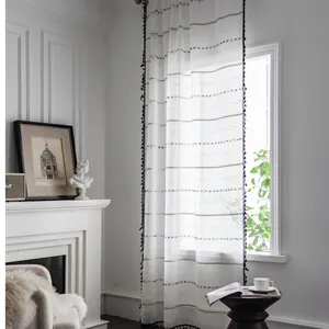 Cortina blanca con rayas de colores y flecos negros para una decoración minimalista
