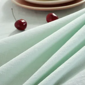 Détail macro de la nappe en coton flammé vert menthe avec franges et texture tissée