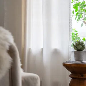 Cortina de lino blanco semitransparente con encaje en una sala de estar minimalista