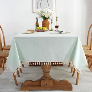Vue détaillée de la nappe en lin de coton vert menthe avec pompons décoratifs blancs