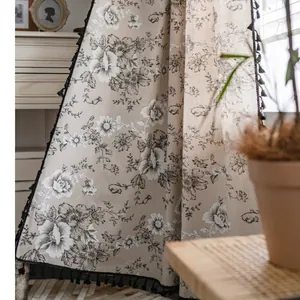 Linen floral curtain with black peony prints and tassels in a cozy rustic room setting