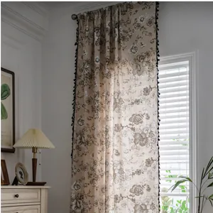 Detail of cotton linen curtain with retro floral pattern and black pompom fringe edge