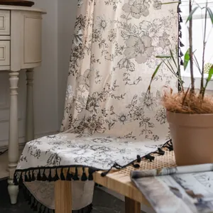 Floral cotton linen curtain with black tassels in American country style on a chair