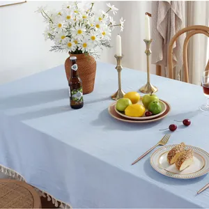 Détail de la nappe en coton et lin bleu clair avec des bordures à franges blanches