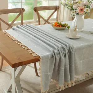 Detail van het lichtblauwe geruite tafelkleed met witte kwastjes in rustieke setting