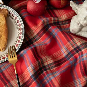 Detailansicht der roten Karo-Weihnachtstischdecke mit festlicher Brot- und Apfeldeko