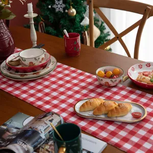 Christmas red and white checkered table runner with festive ceramic tableware