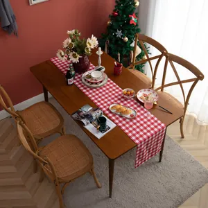 Red and white buffalo plaid table runner on a dining table with Christmas decor