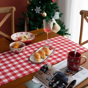 Close-up of red and white plaid cotton linen table runner in a festive Christmas setting
