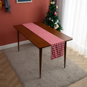Detail of red and white gingham table runner on dark wood table for Christmas decor