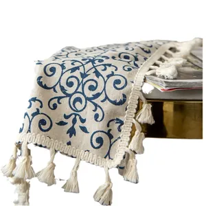 Vintage blue floral cotton linen cafe curtain with decorative tassels on a white background