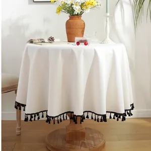 Mantel redondo de lino blanco con elegantes borlas negras para decoración de mesa nórdica
