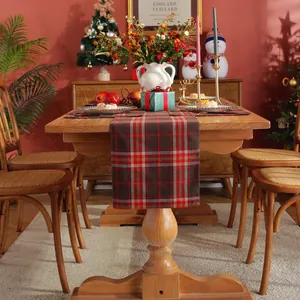 Close-up of a rustic red and gray plaid cotton linen table runner on a wooden table