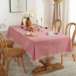 Nappe à carreaux rouge et blanc en lin avec pompons blancs sur une table en bois massif