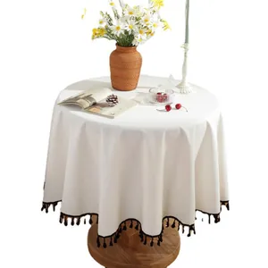 Thick creamy white round cotton linen tablecloth with elegant black tassels and fringe