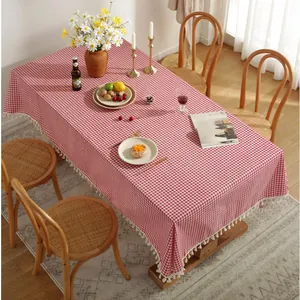 Détail de la nappe en coton et lin à carreaux rouges et blancs avec bordure à pompons