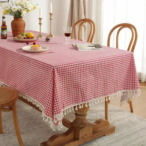 Nappe à carreaux rouges et blancs en coton et lin avec pompons sur une table en bois