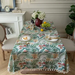 Close-up of tropical leaf print tablecloth with elegant off-white short fringe tassels