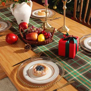 Close-up of a festive double-layer plaid table runner with Christmas decor on a dining table