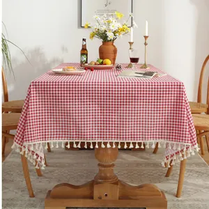 Nappe à carreaux rouges et blancs avec bordures à pompons blancs sur table en bois