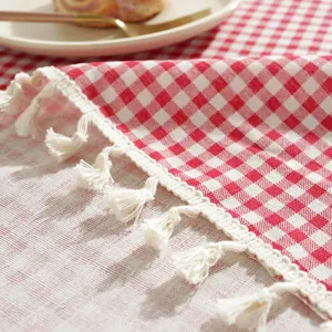 Détail de nappe à carreaux rouges et blancs avec bordures décoratives en franges de coton