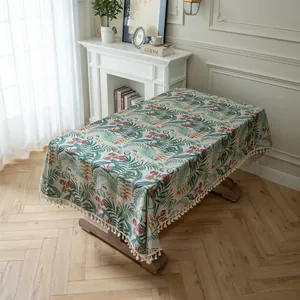 Close-up of tropical palm leaf pattern on linen tablecloth with elegant fringe trim