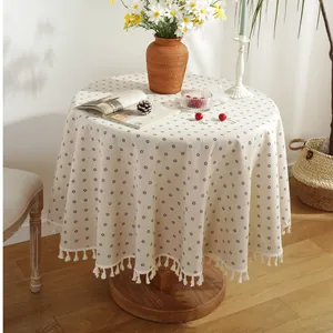 Nordic round tablecloth with blue daisy prints and white tassel edges on wooden table