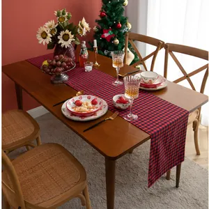 Detail of red and black buffalo plaid table runner on dark wood dining table decoration