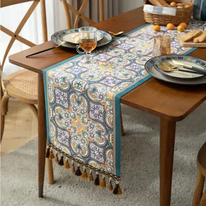 Détail du tissage jacquard mandala bohème et des pompons colorés sur le chemin de table