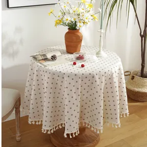 Nordic round tablecloth with small daisy print and elegant fringe edges on wood table