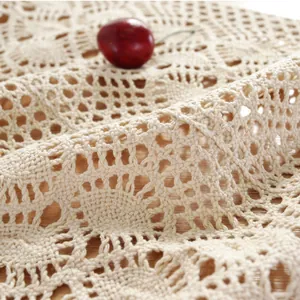 Close-up of beige crochet table runner featuring intricate geometric hollow patterns